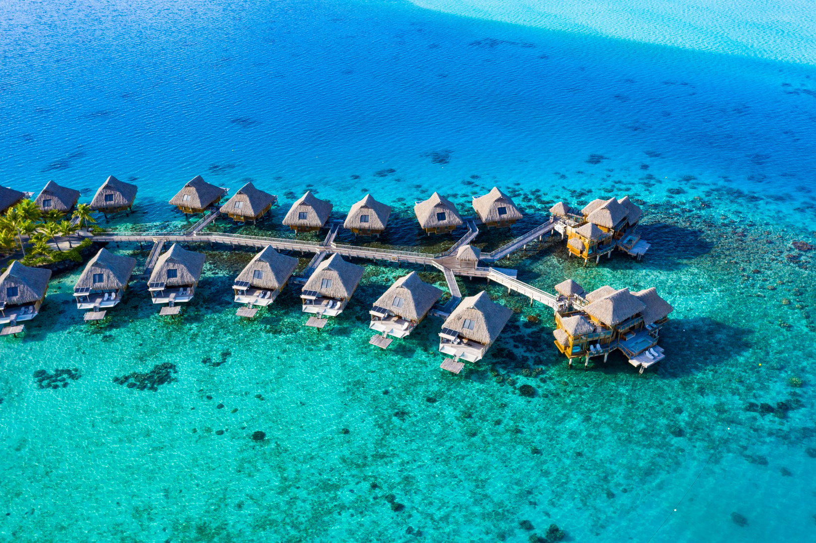 Travel Vacation Paradise Aerial Image with Overwater Bungalows in Coral Reef Sea